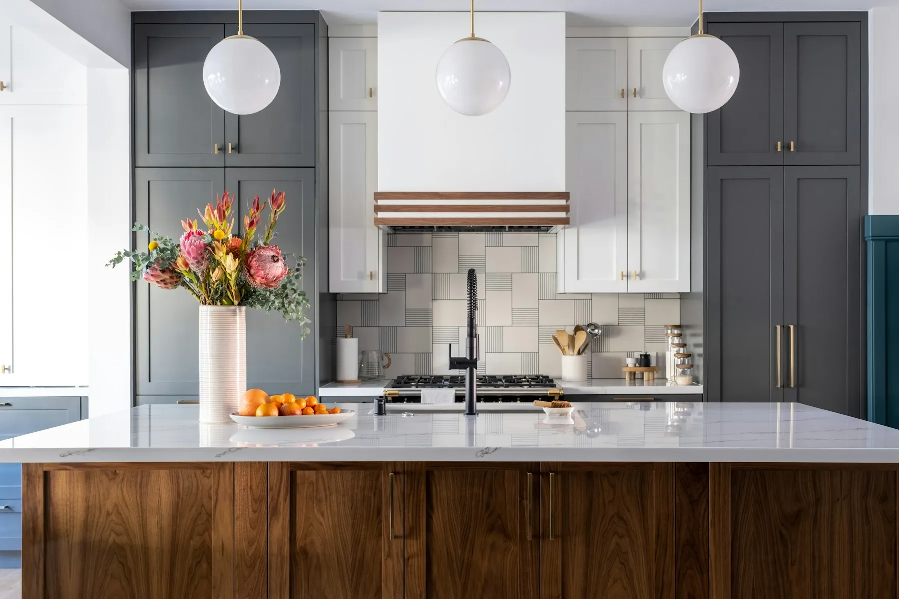Remodeled kitchen with a walnut island, white counters and pendant lights