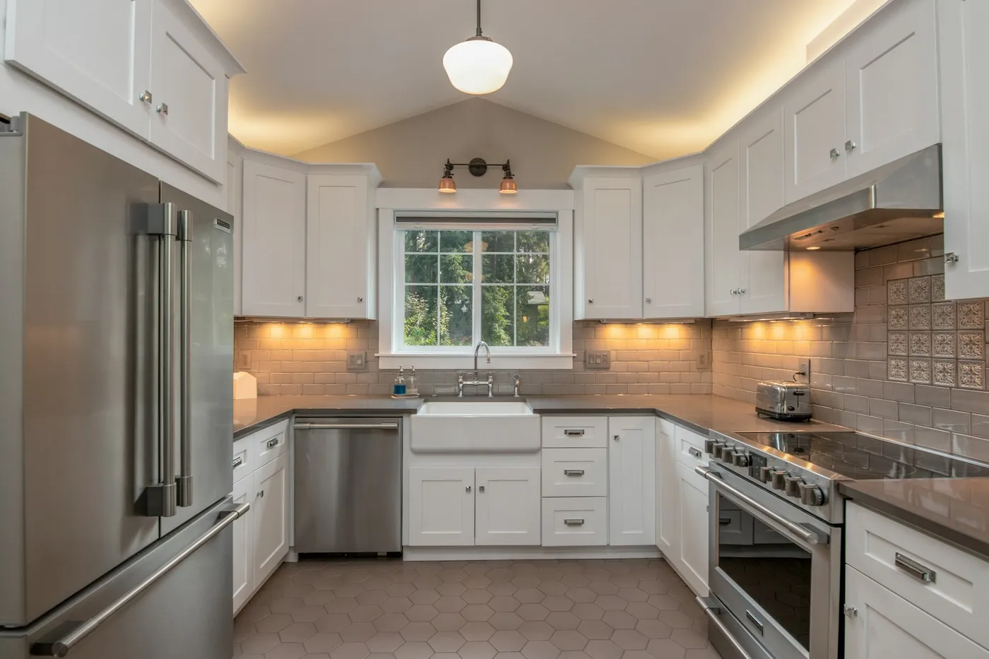 White kitchen with subway tile backsplash and pendant light